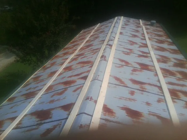 Rusted metal roof panels with new wood purlins before replacement — Storm Damage Roof Repair in Succasunna by Roofing Brothers