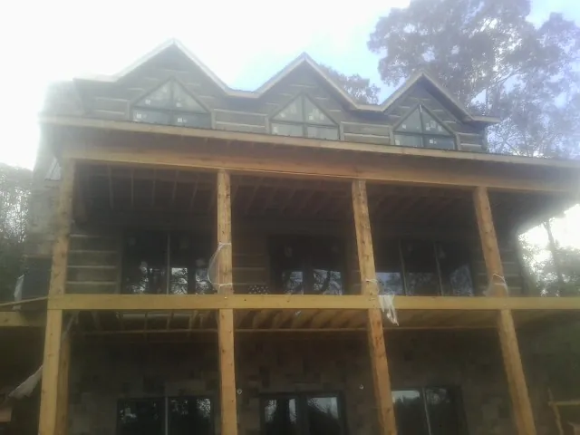 Dormers and porch framing on a large log home under construction — Roof Coating work by our crew in Succasunna