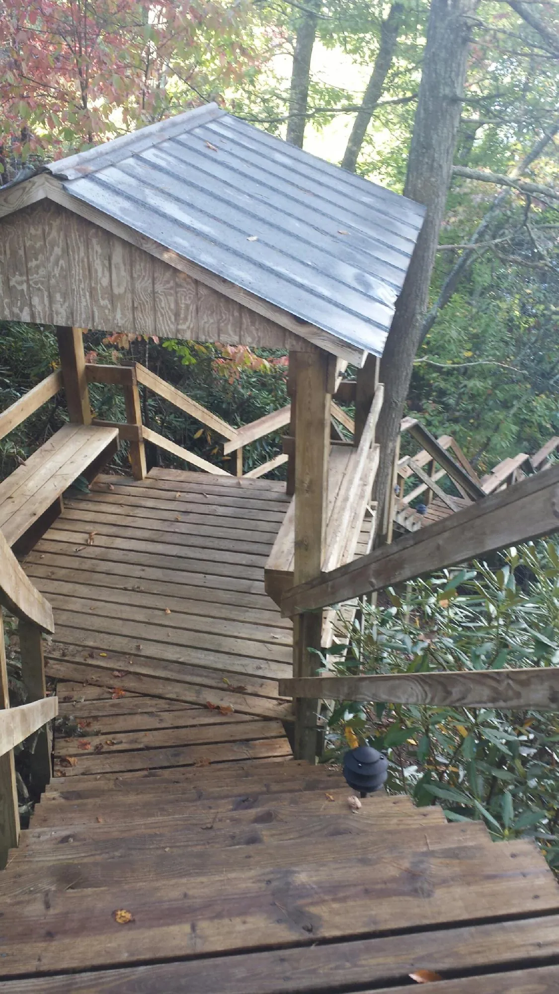 Metal roofed shelter over wooden steps on a wooded walkway — Skylight Repair & Installation work by our crew in Succasunna