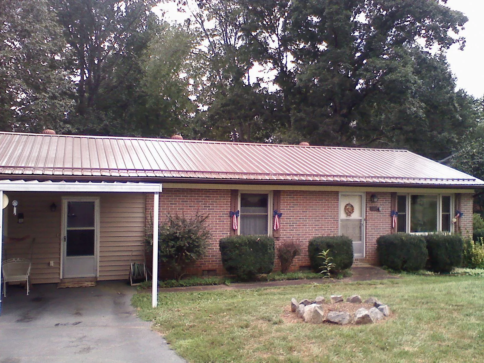 Bronze metal roof and carport on a brick ranch home — Roof Repair work by our crew in Succasunna