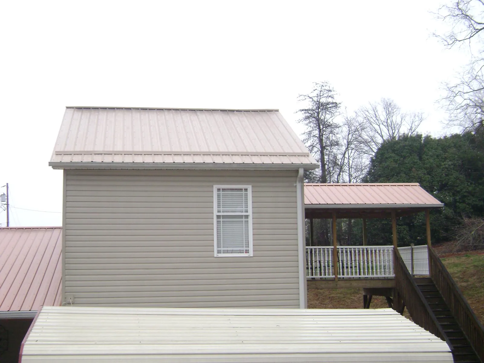 Tan metal roofs on a two story addition and attached porch, from a Roof Replacement job in Succasunna
